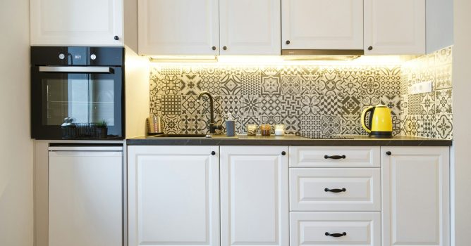 Beautiful home kitchen with white cabinets and backlight